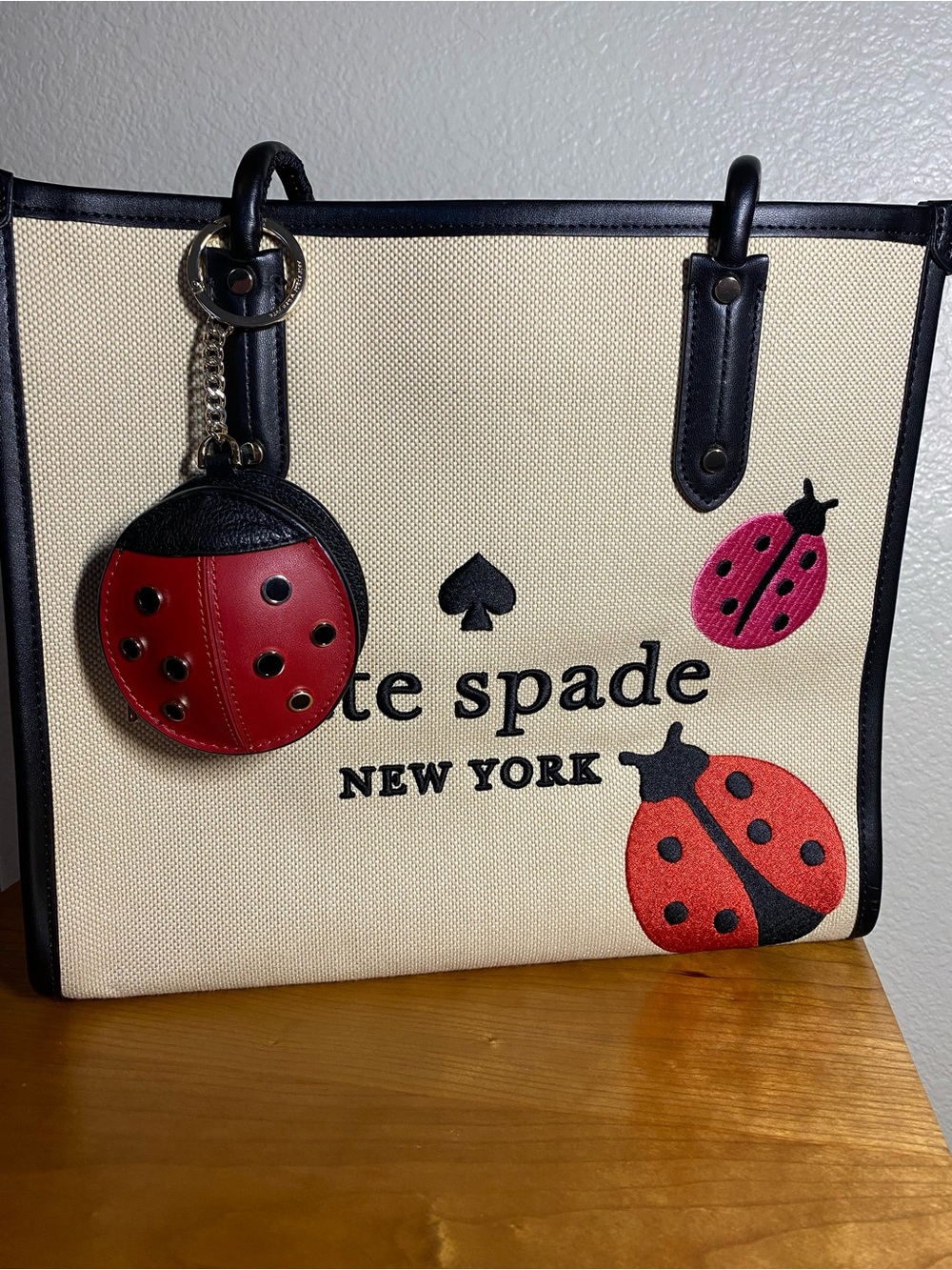 kate spade Beige Canvas Tote with Red Ladybug Charm and Black Trim